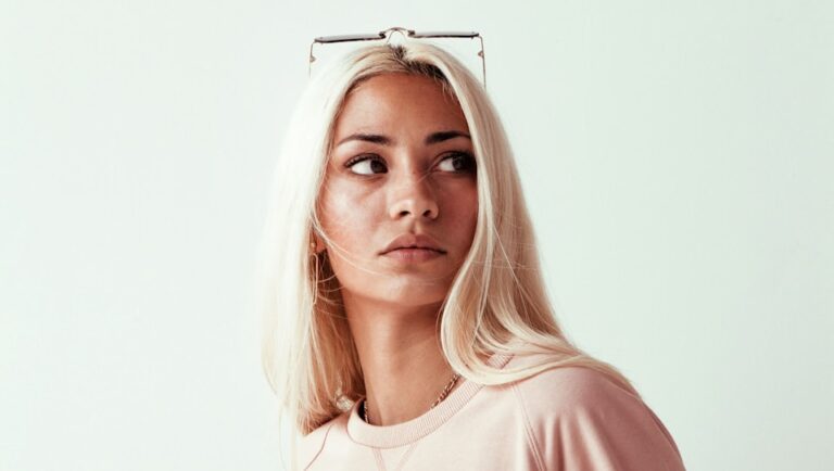 woman in pink long sleeve shirt with platinum blonde hair